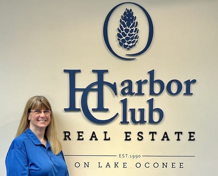 laurie rimes standing in front of harbor club signage