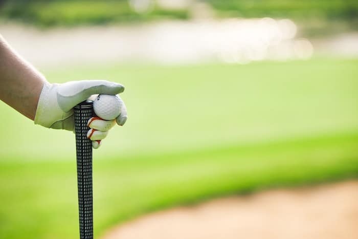 person hold a golf ball and club